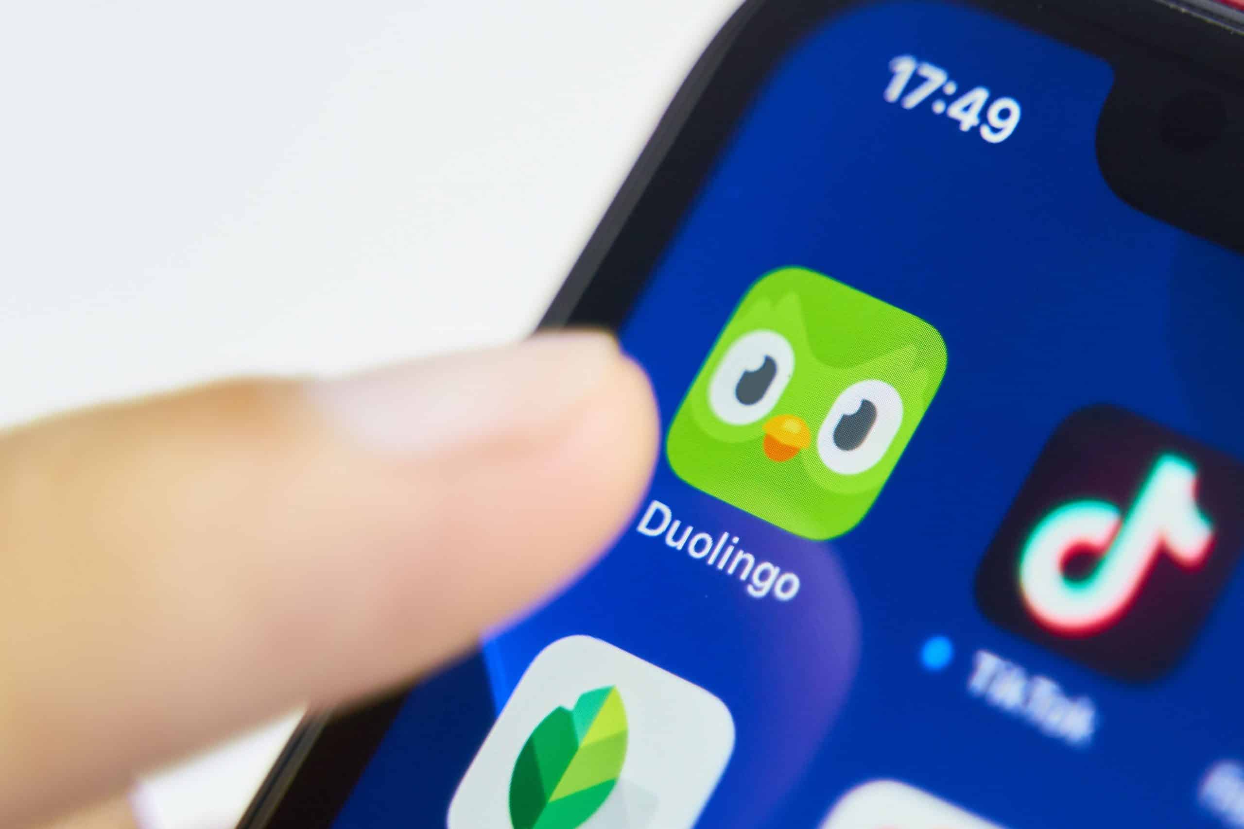 is Duolingo good for learning languages header image featuring a finger tapping onto the Duolingo app icon.