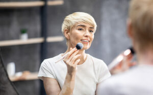 Woman applying one of the best bb creams to her face with a brush.