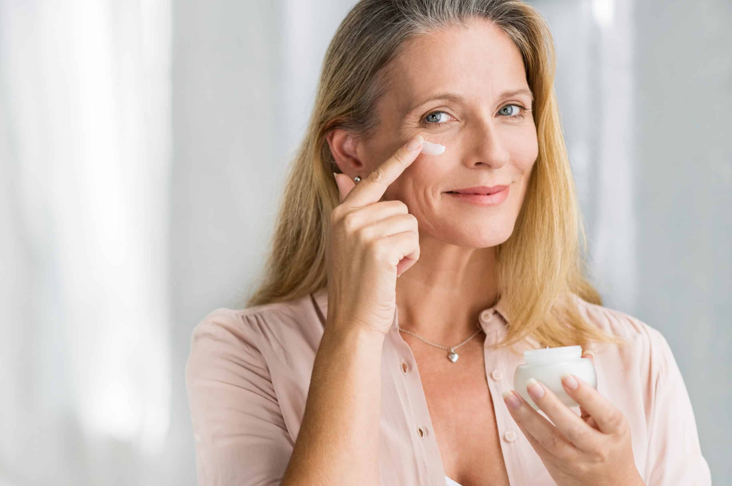 Woman applying one of the best anti aging eye creams from 2022 to her undereye.