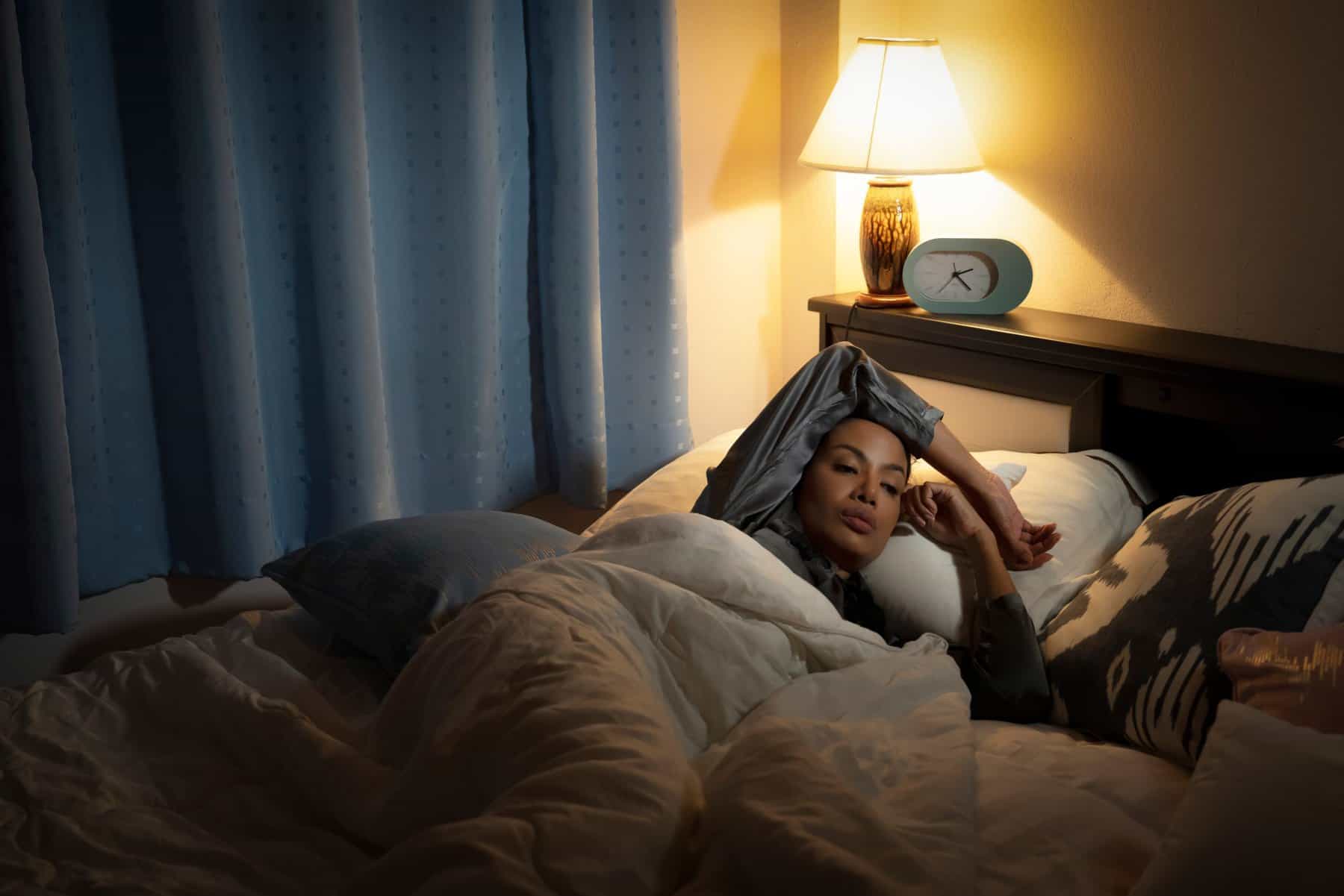 Woman laying in bed preparing to sleep.