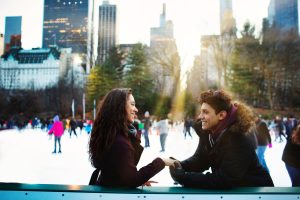 Couple on an ice rink in New York are celebrating Valentine's Day in Manhattan and holding hands.
