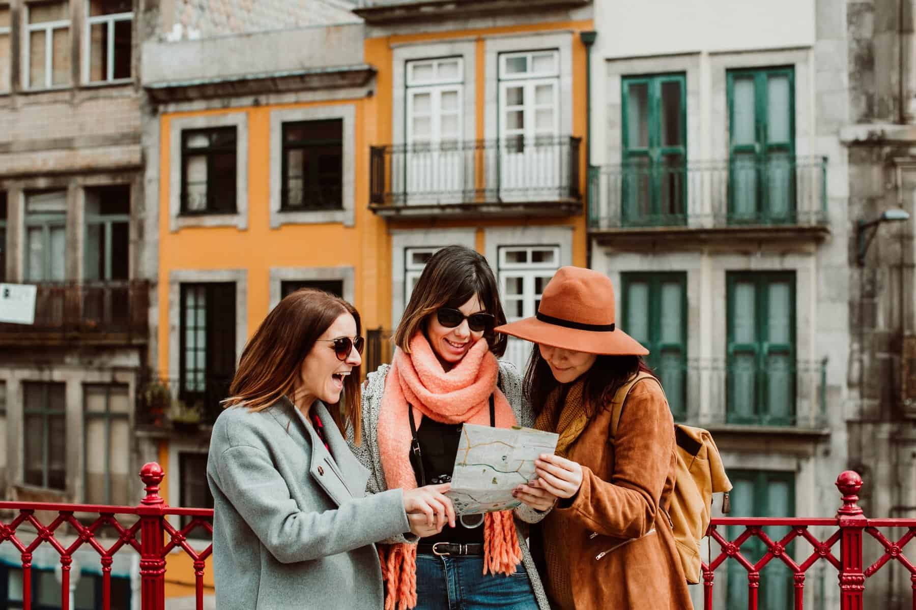 A group of woman outside consulting a map. They look happy.