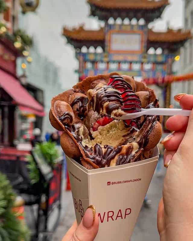 A unique waffle cone filled with ice cream and chocolate sauce. 