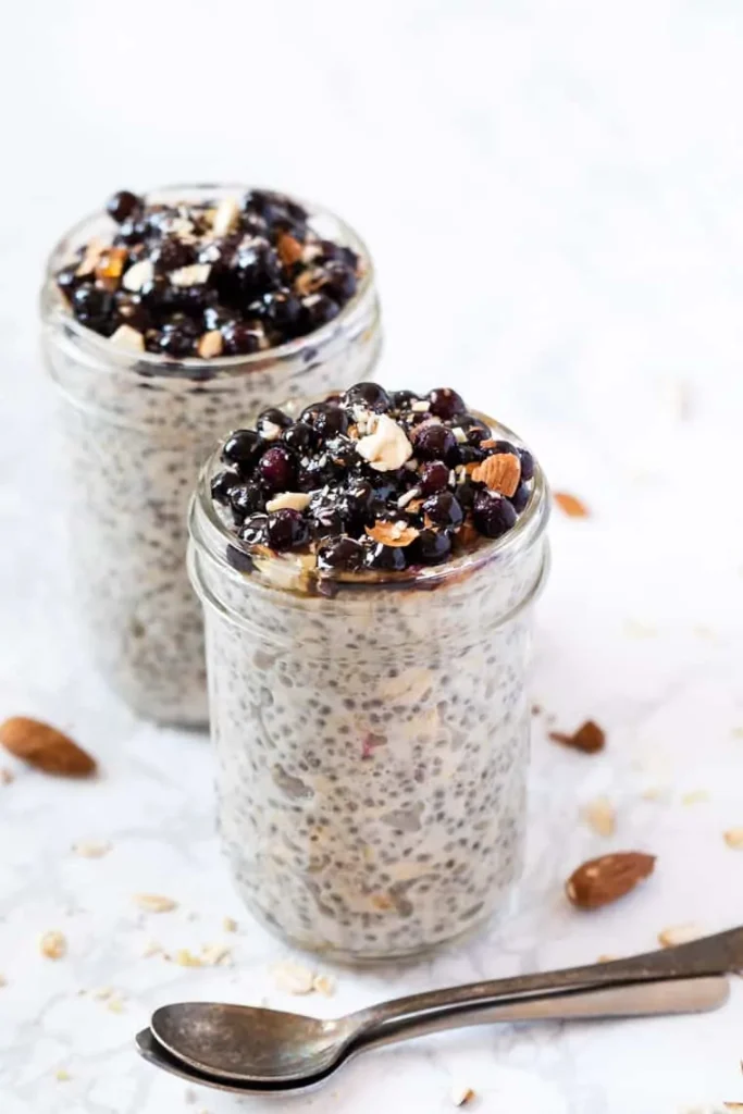 A jar of quinoa and oats topped with berries and almonds. 