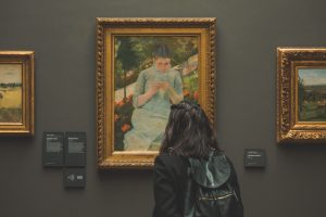 A woman admiring a painting from the Monet Garden.