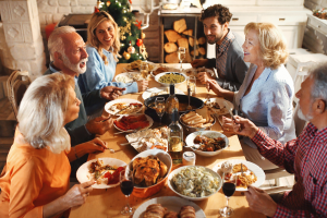 A family gathered around the table having Thanksgiving meal.