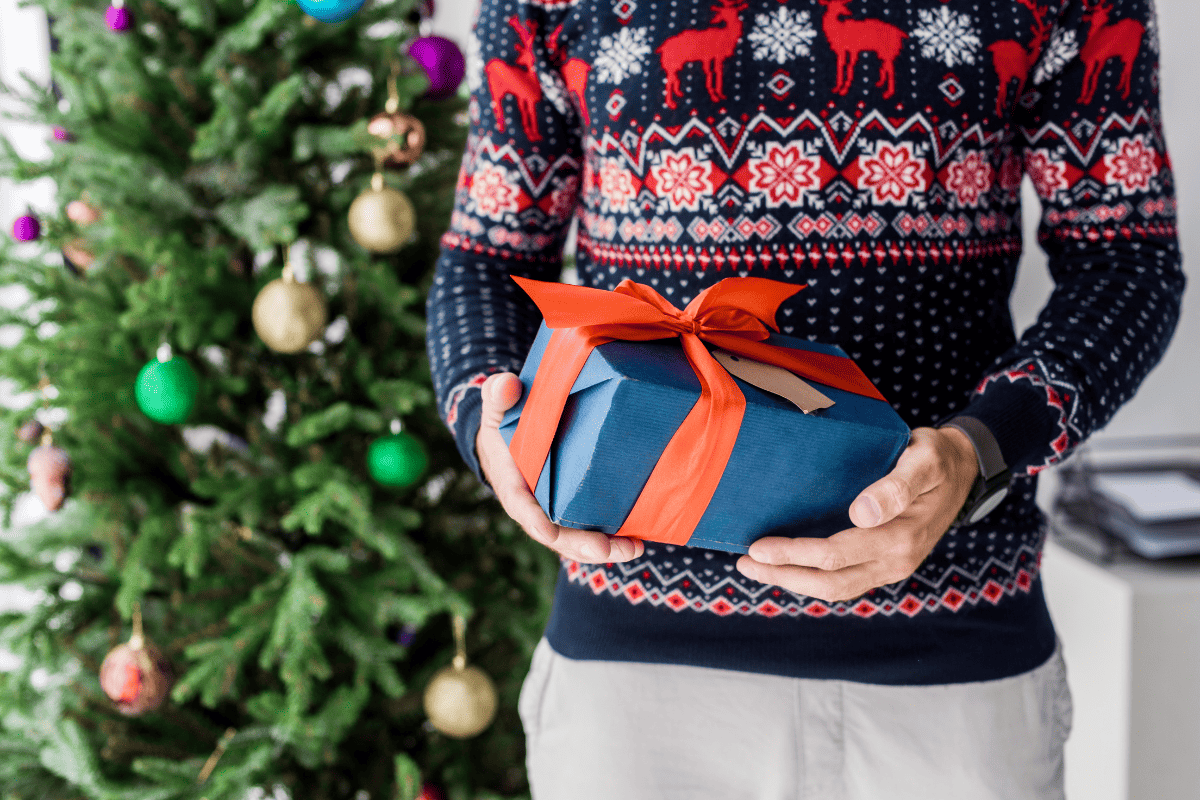 A man holding one of many gift for guys on Christmas.