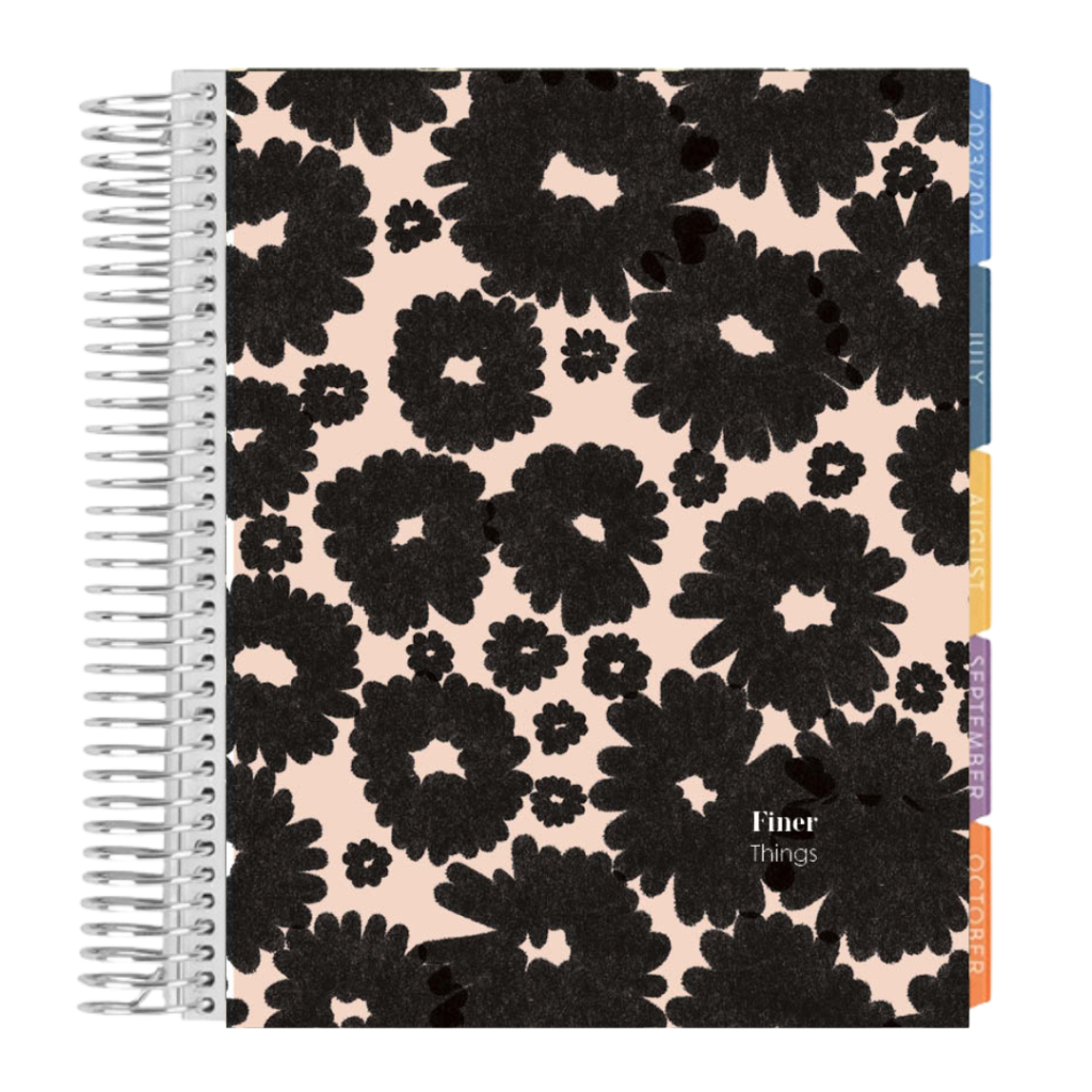A spiral bound 2024 planner features large black flowers. 