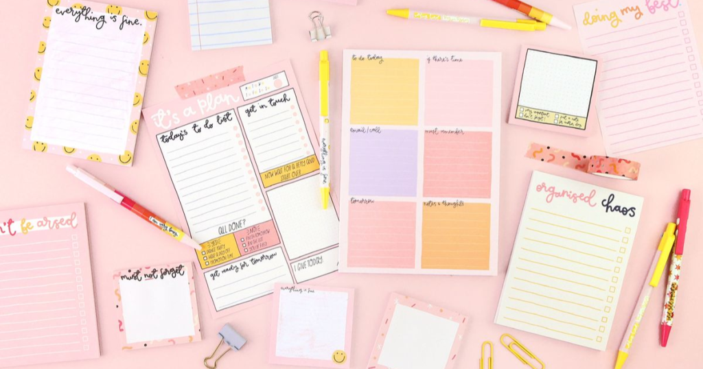 An array of colorful stationery on a pink backdrop. 